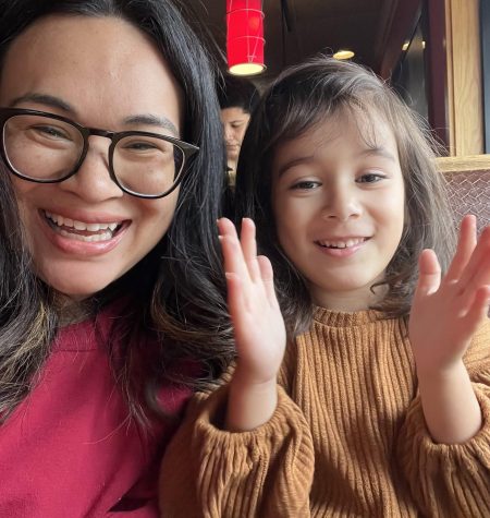 A joyful mother and daughter enjoying a fun moment together at a cozy restaurant.