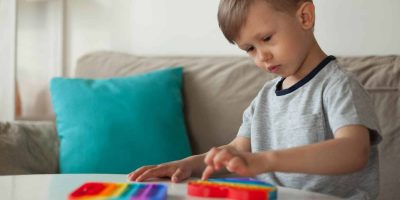 Child playing with colorful toys on a table in a cozy room.
