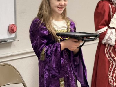 Girl in a purple costume smiles joyfully at the AbleFamilies event.