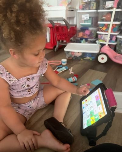Toddler engaged with iPad, exploring learning apps and interactive play at home.